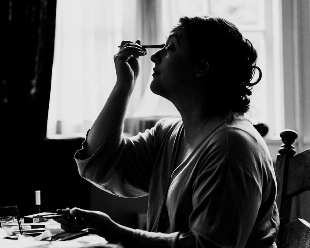 wedding photograph of bride putting on makeup