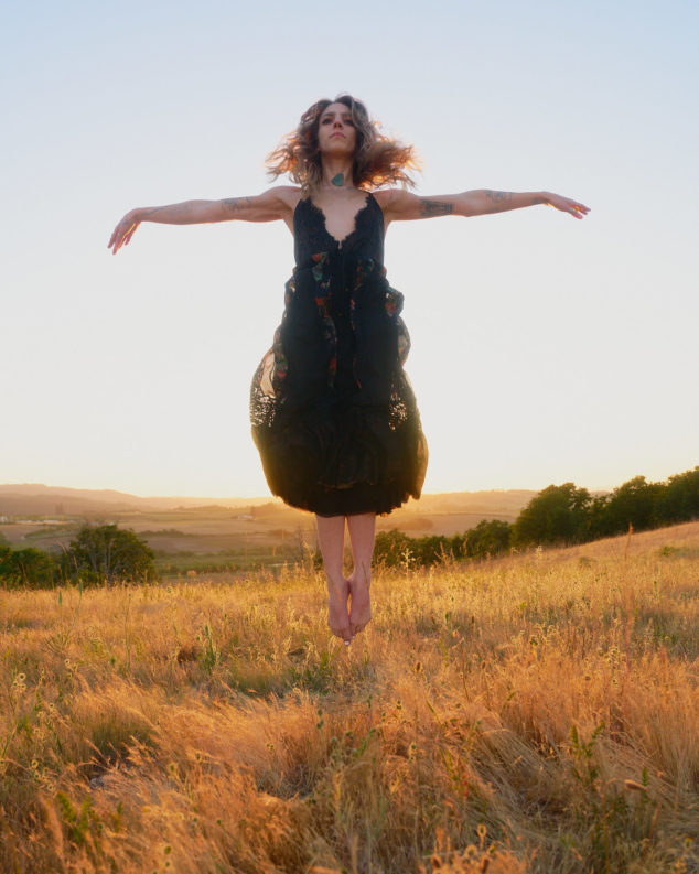 photograph of a levitating woman in a sunset