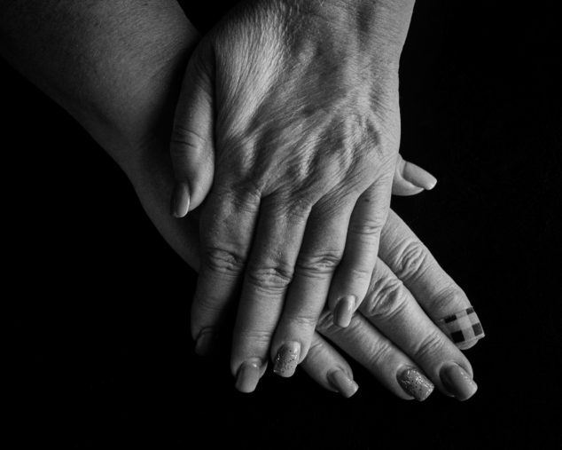 black and white image of a womans hands crossed